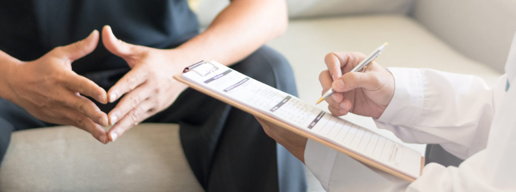 Psychological exam. Doctor consulting with male patients in hospital exam room. 