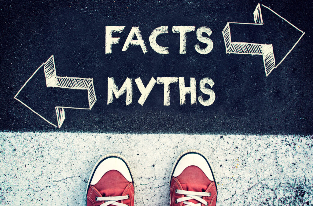 Myths versus facts - standing over a sign of facts and myths
